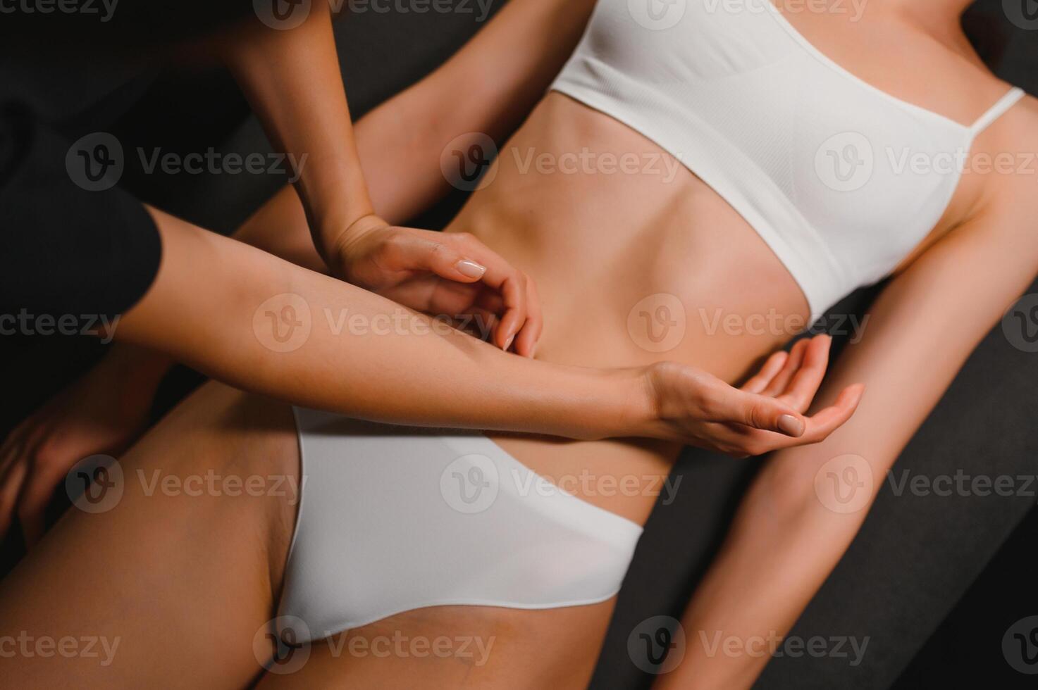 Young woman receiving abdominal massage in spa salon photo