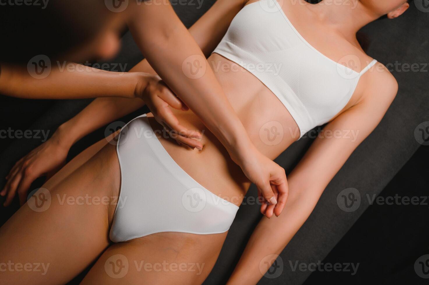 A masseuse woman doing an oil massage to woman on the stomach photo