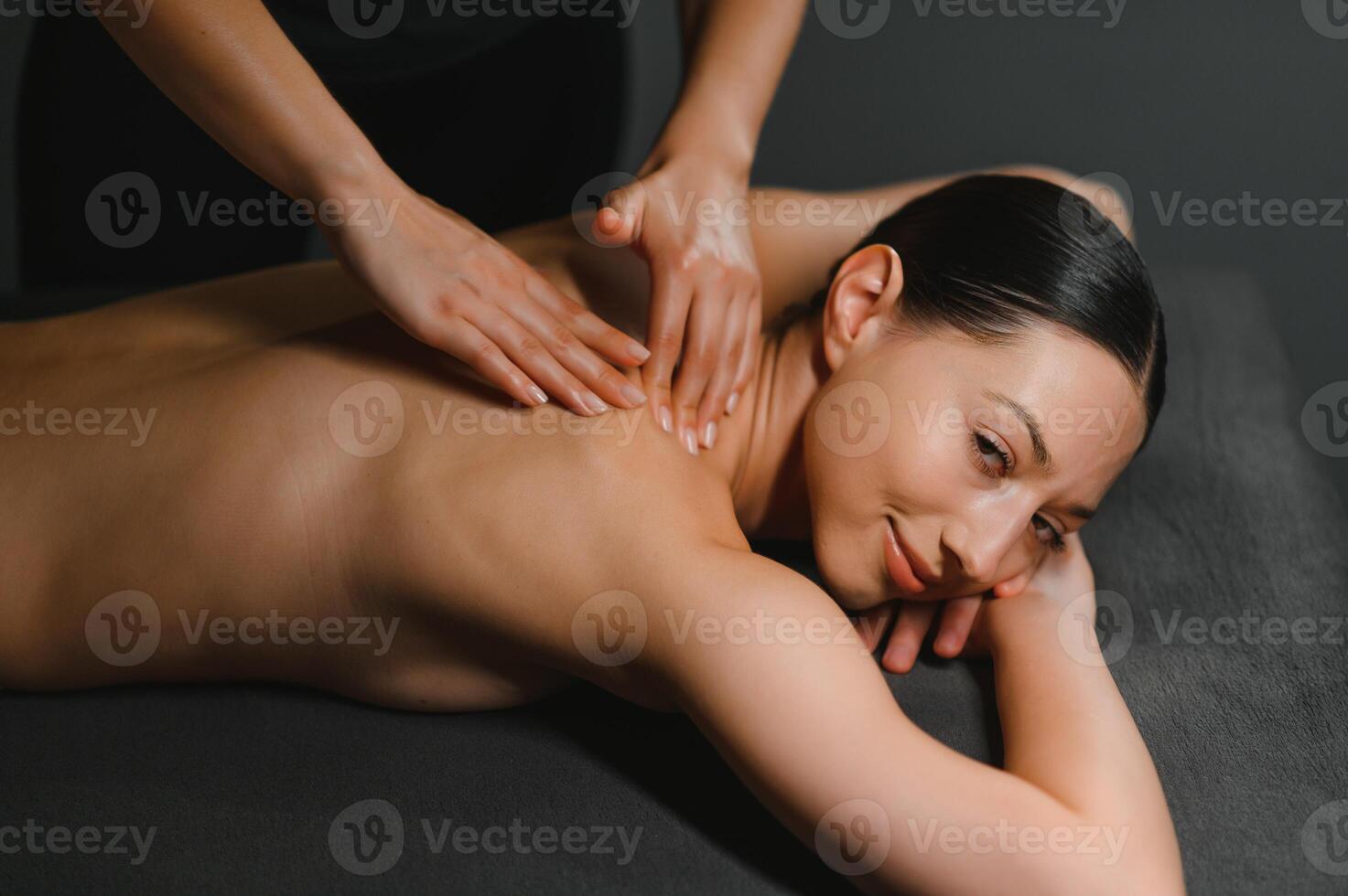 Masseur doing massage on woman body in the spa salon. Beauty treatment concept photo