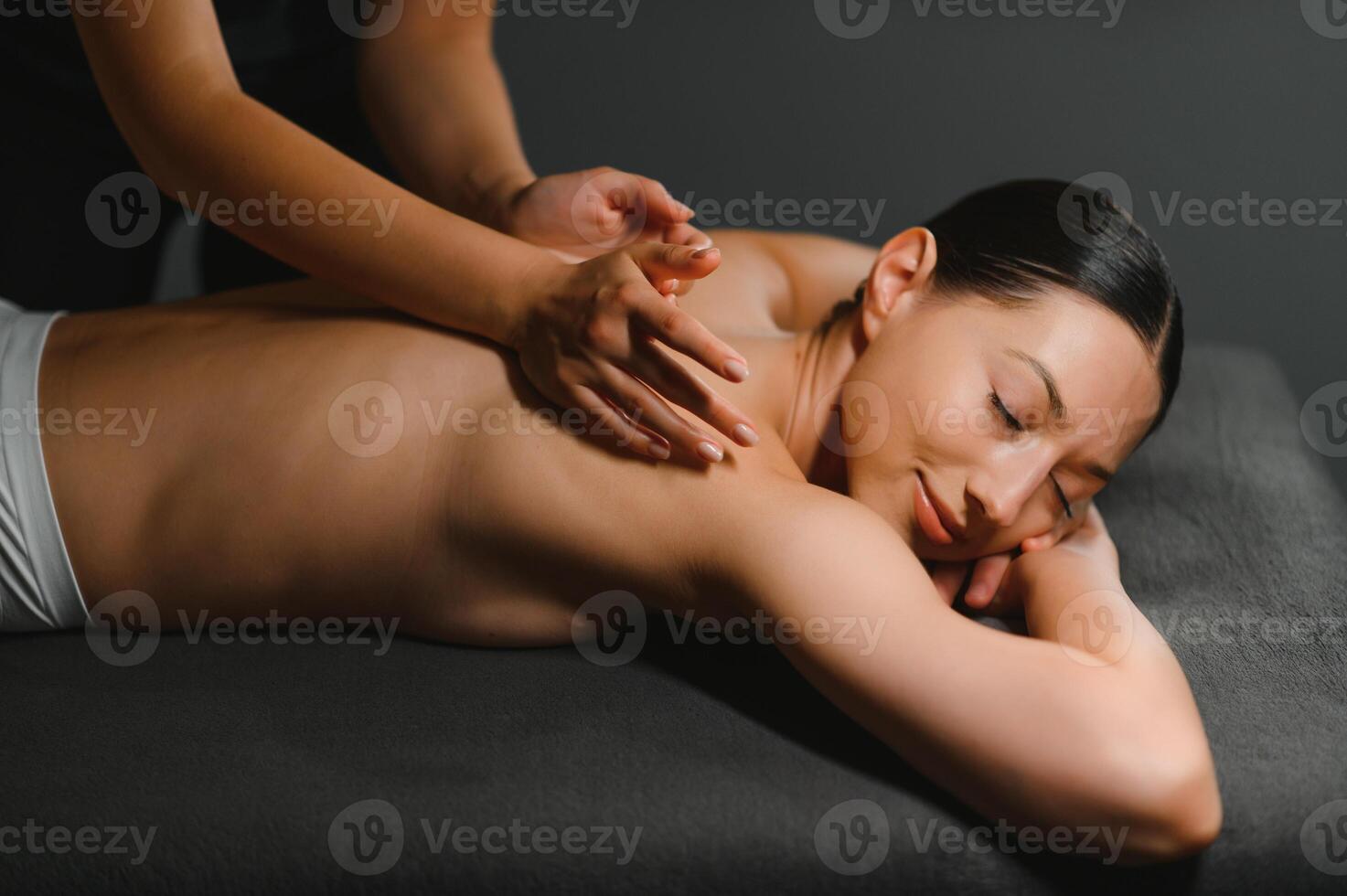 Masseur doing massage on woman body in the spa salon. Beauty treatment concept photo