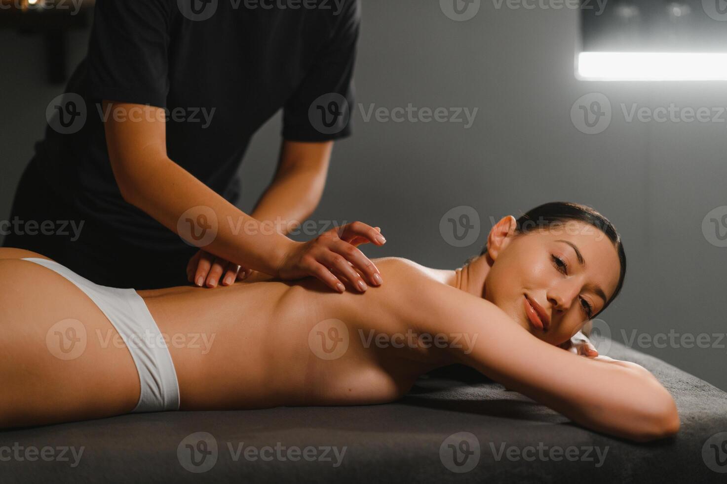 Masseur doing massage on woman body in the spa salon. Beauty treatment concept photo