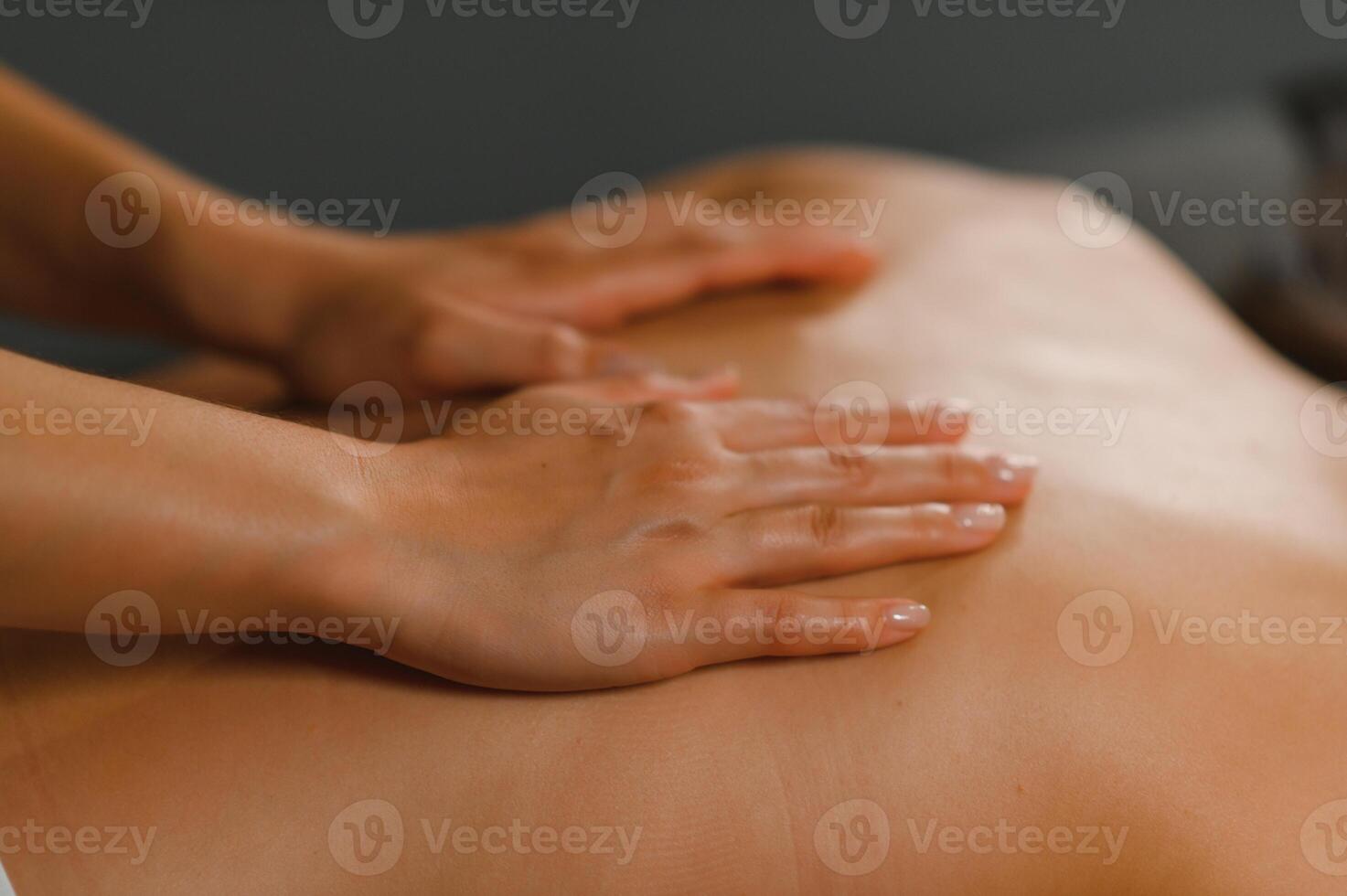 Masseur doing massage on woman back in the spa salon photo