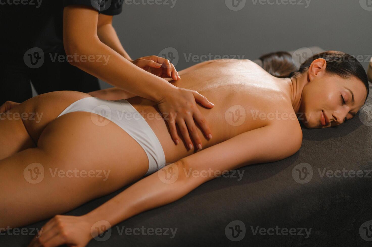 Masseur doing massage on woman body in the spa salon. Beauty treatment concept photo
