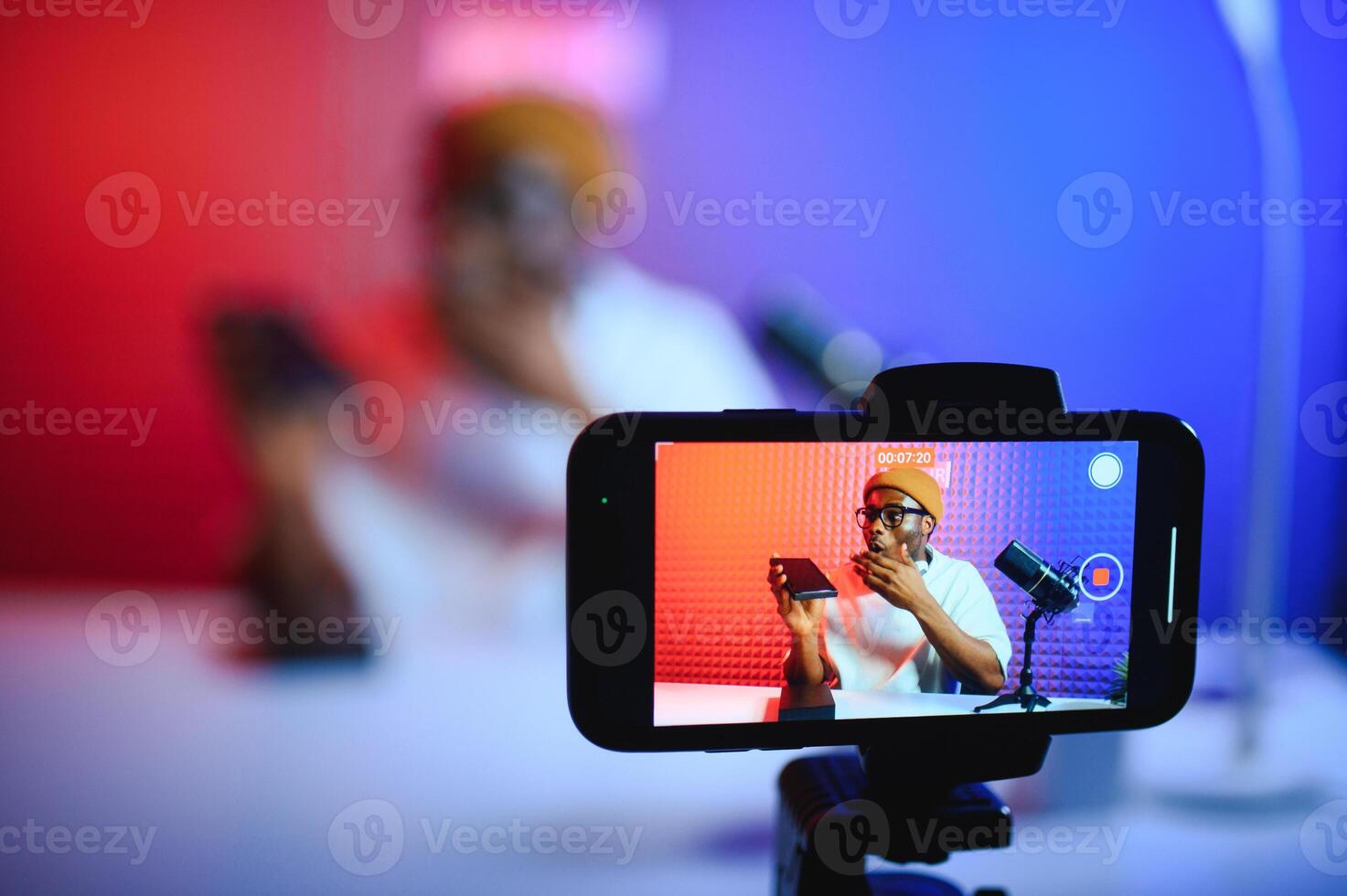 African american blogger unboxing new smartphone and recording on camera photo