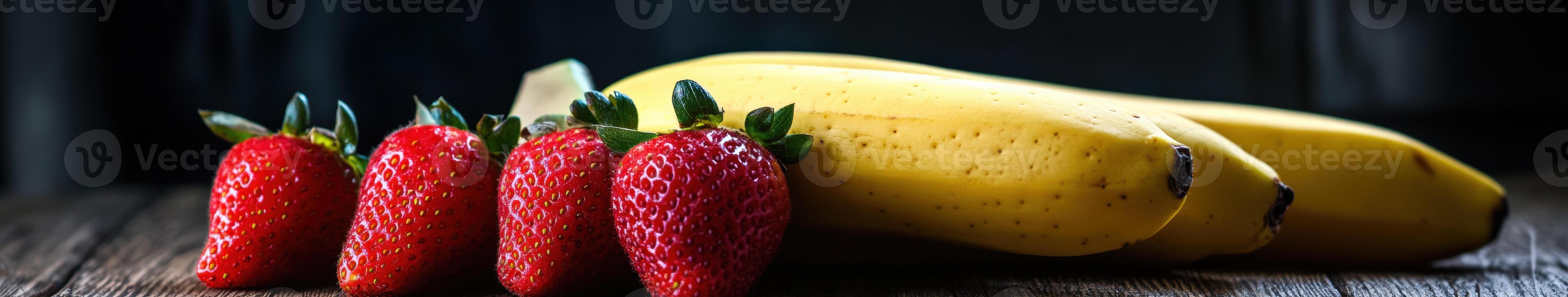 Fresh strawberries and bananas on a wooden table in natural light photo