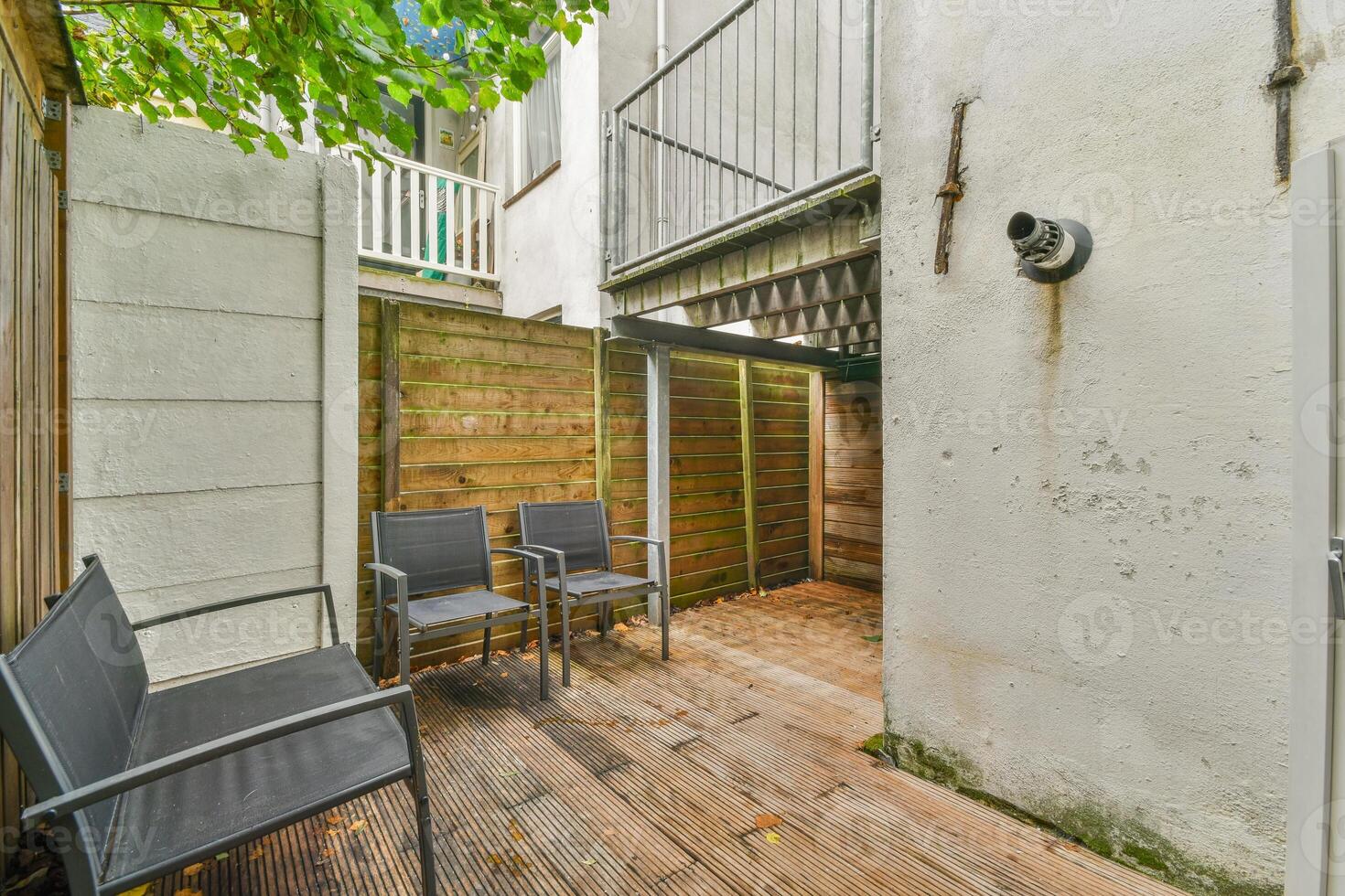 A patio with chairs and a wooden fence photo