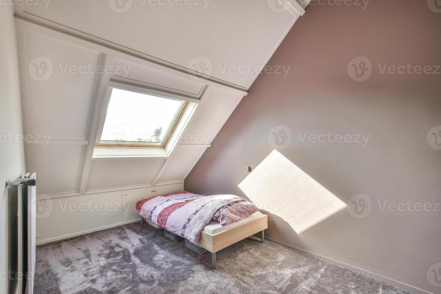 A bed in an attic with a window photo