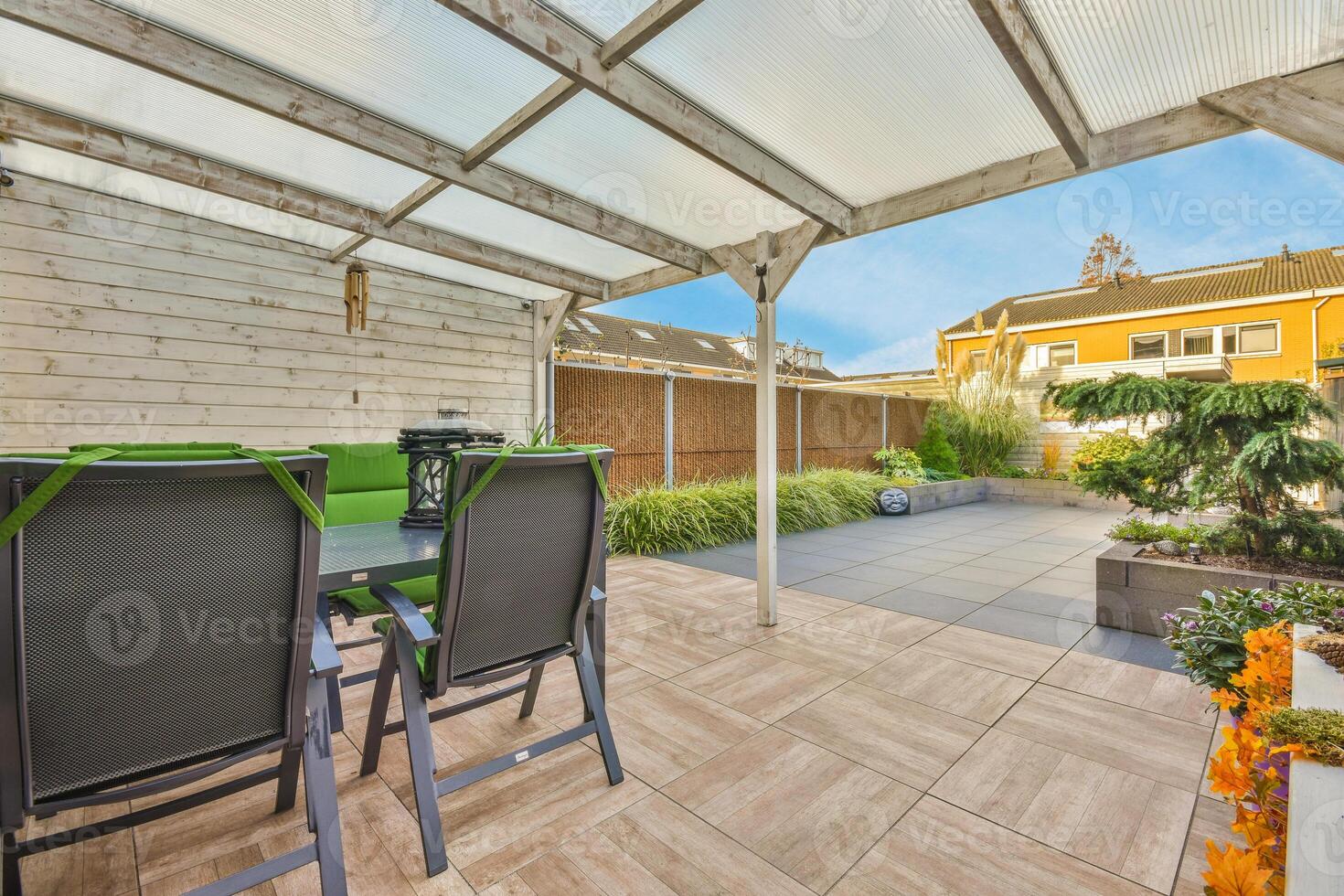 A patio with green chairs and a table photo