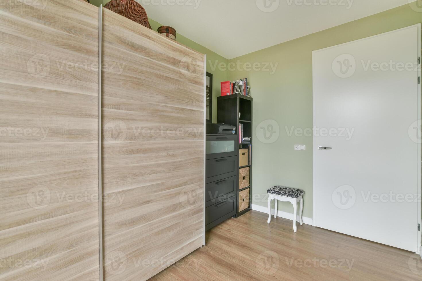 A bedroom with a wooden cabinet and a wooden floor photo