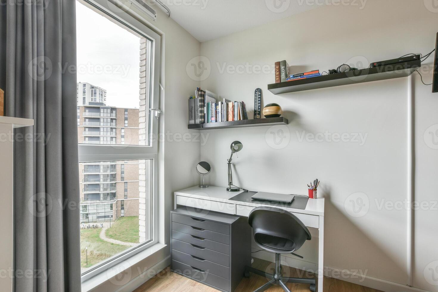 A desk and chair in a room with a window photo