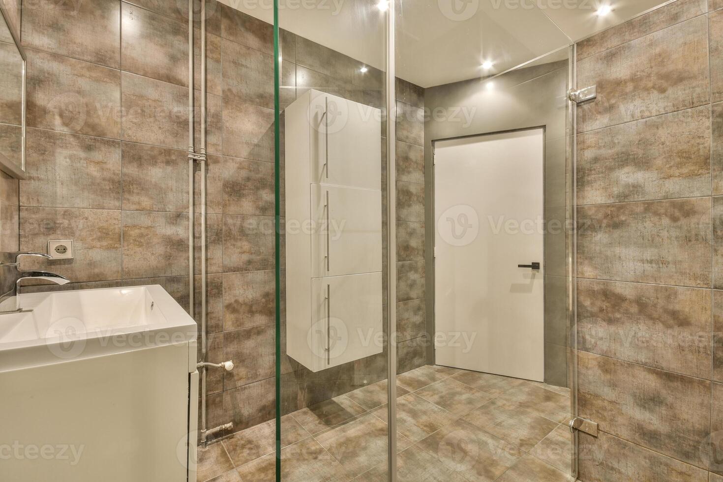 A bathroom with a glass shower stall and a sink photo