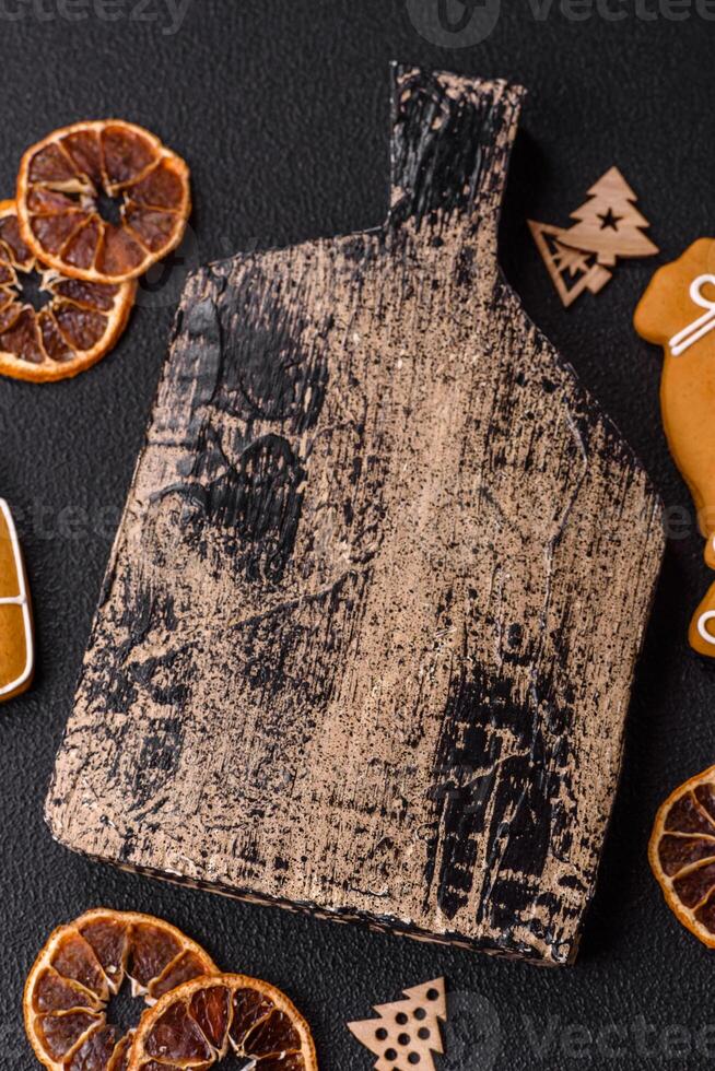 Empty wooden cutting board with copy space with gingerbread cookies and Christmas decor photo