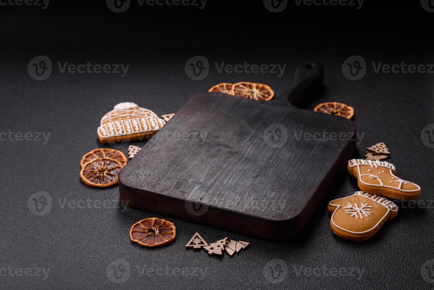 Empty wooden cutting board with copy space with gingerbread cookies and Christmas decor photo