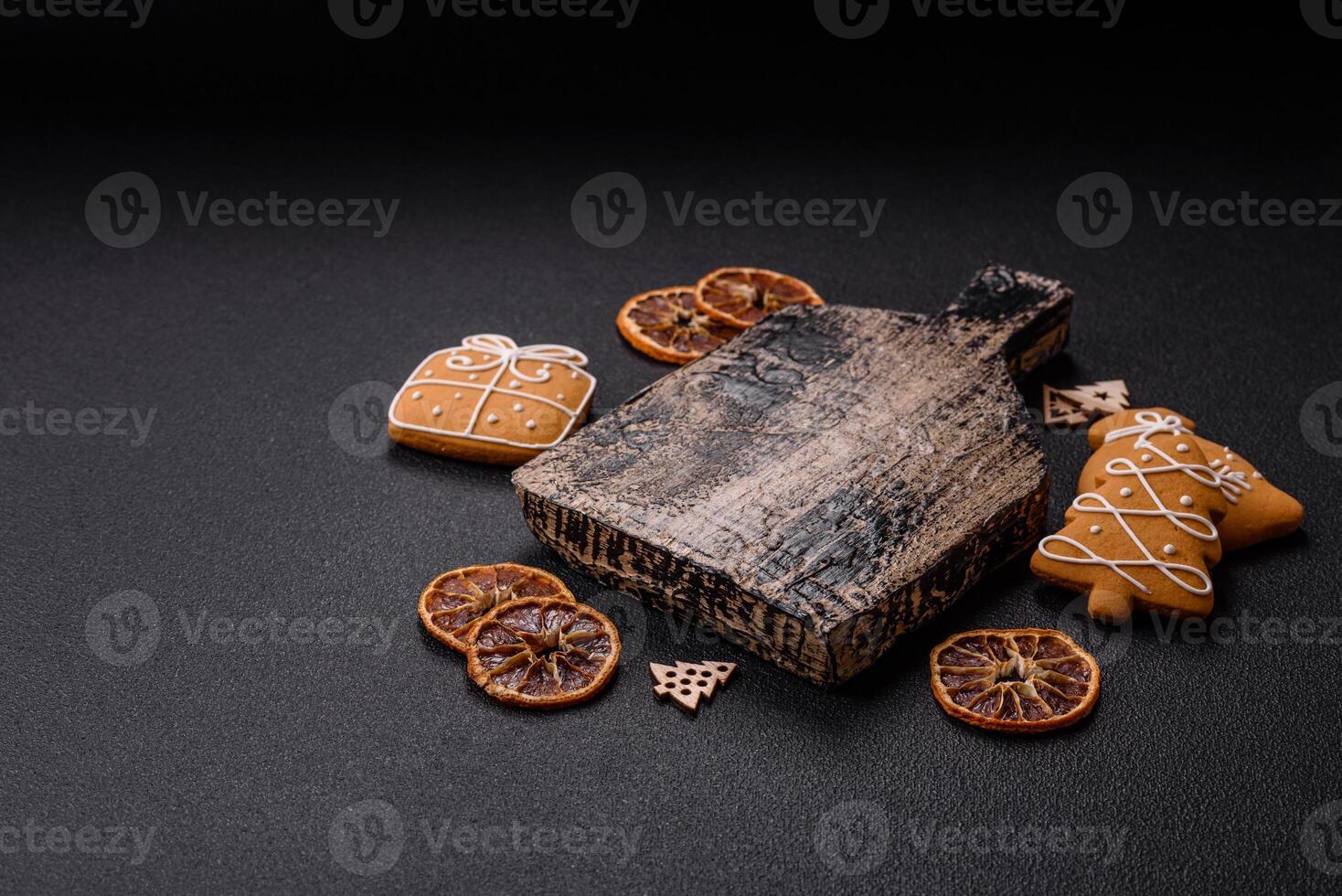 Empty wooden cutting board with copy space with gingerbread cookies and Christmas decor photo