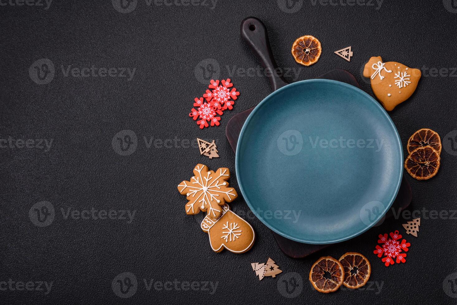 Empty round ceramic copy space plate with gingerbread cookies and Christmas elements photo