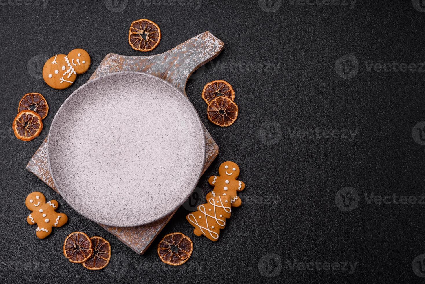 Empty round ceramic copy space plate with gingerbread cookies and Christmas elements photo