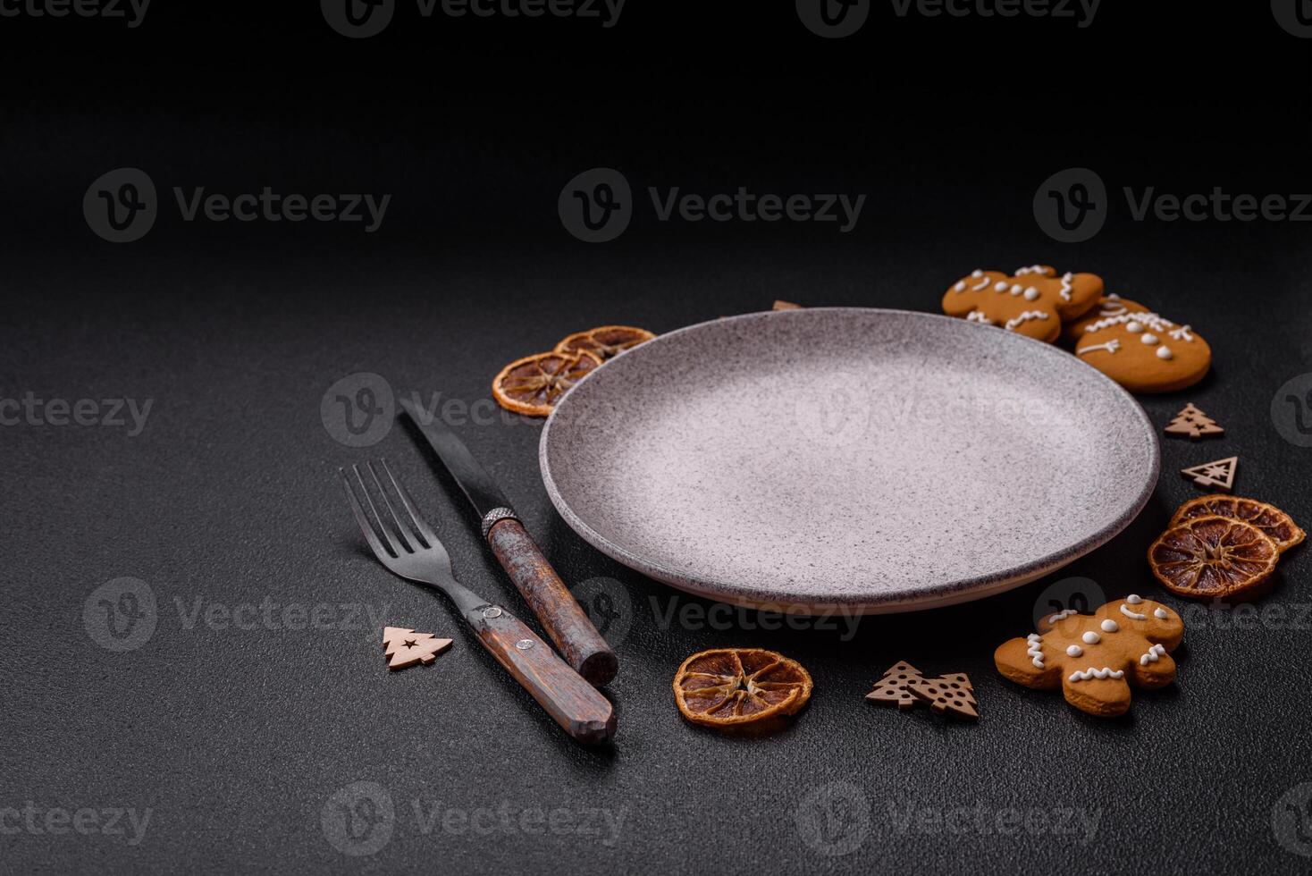 Empty round ceramic copy space plate with gingerbread cookies and Christmas elements photo