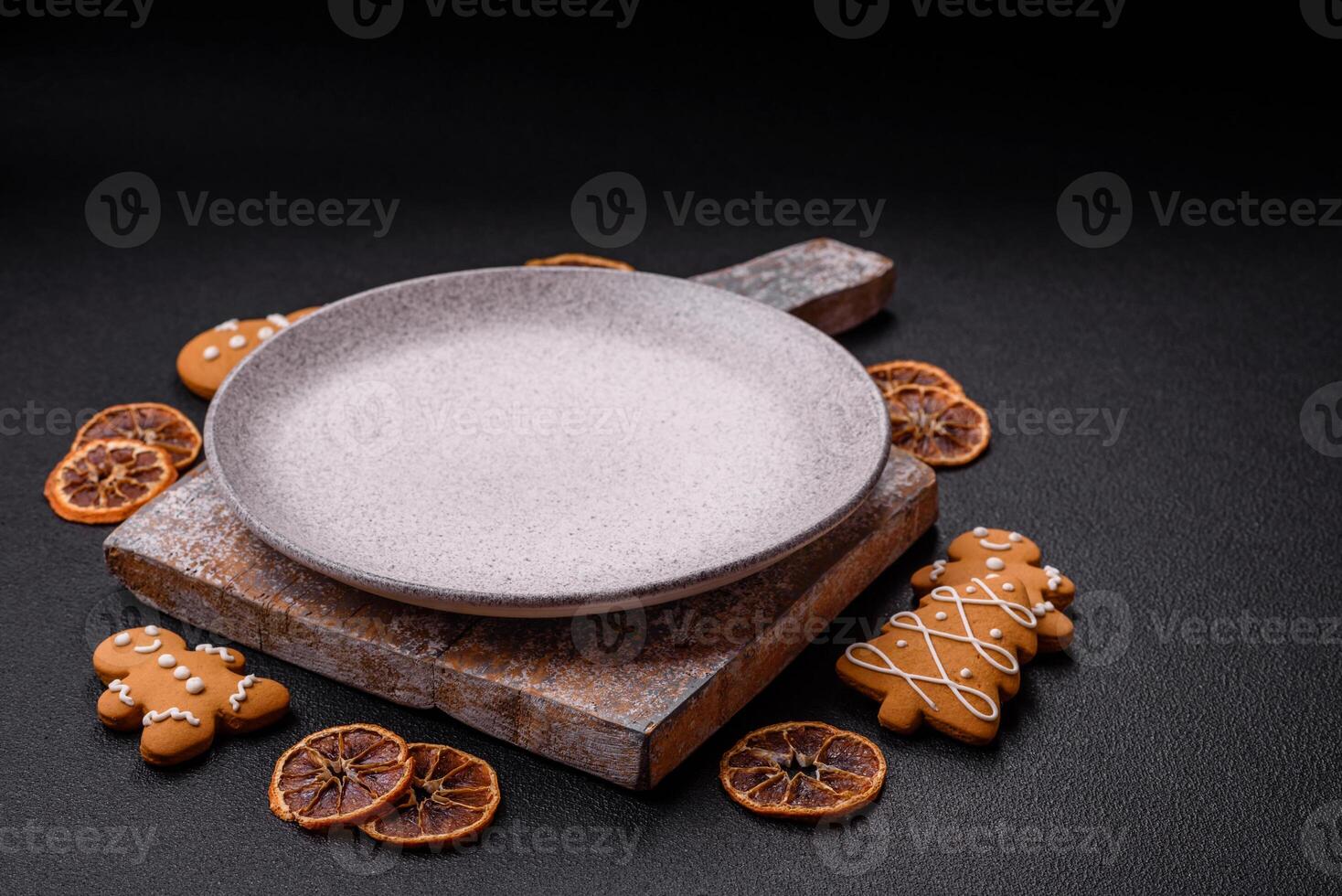 Empty round ceramic copy space plate with gingerbread cookies and Christmas elements photo