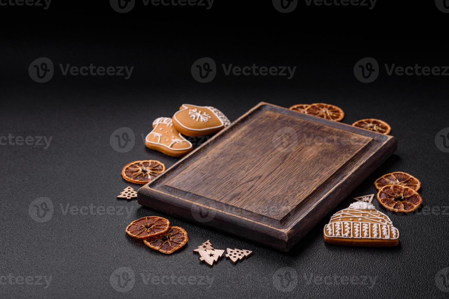 Empty wooden cutting board with copy space with gingerbread cookies and Christmas decor photo