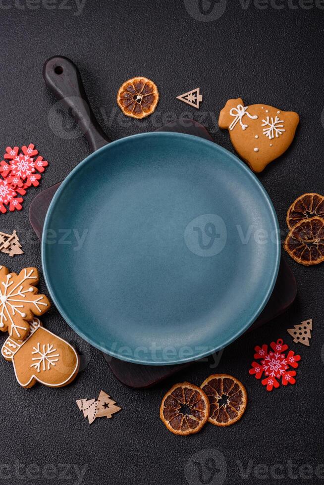 Empty round ceramic copy space plate with gingerbread cookies and Christmas elements photo
