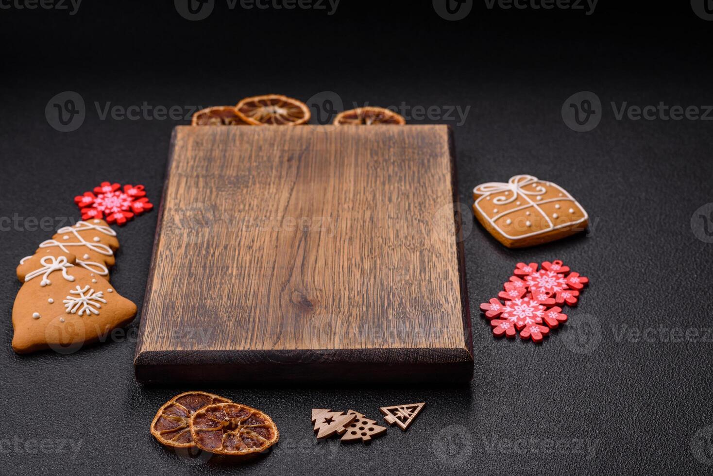 Empty wooden cutting board with copy space with gingerbread cookies and Christmas decor photo