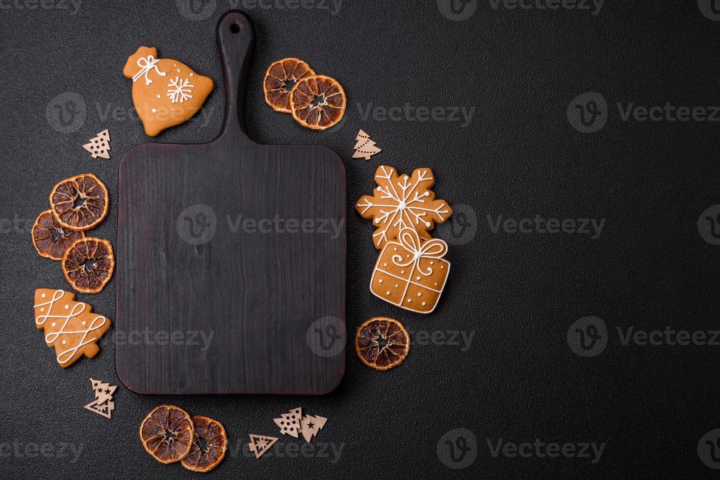 Empty wooden cutting board with copy space with gingerbread cookies and Christmas decor photo