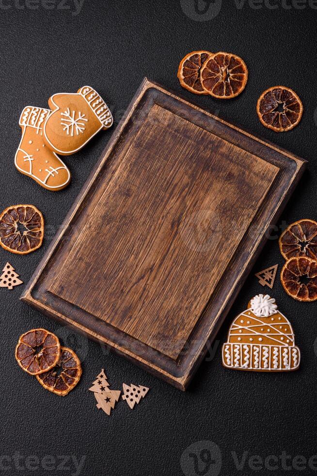 Empty wooden cutting board with copy space with gingerbread cookies and Christmas decor photo