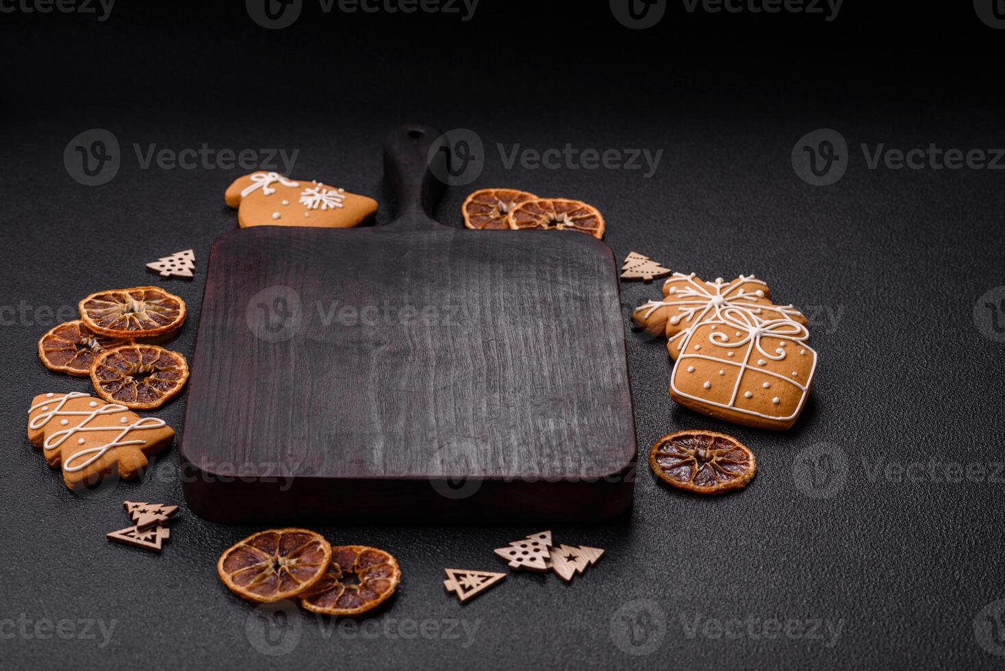 Empty wooden cutting board with copy space with gingerbread cookies and Christmas decor photo