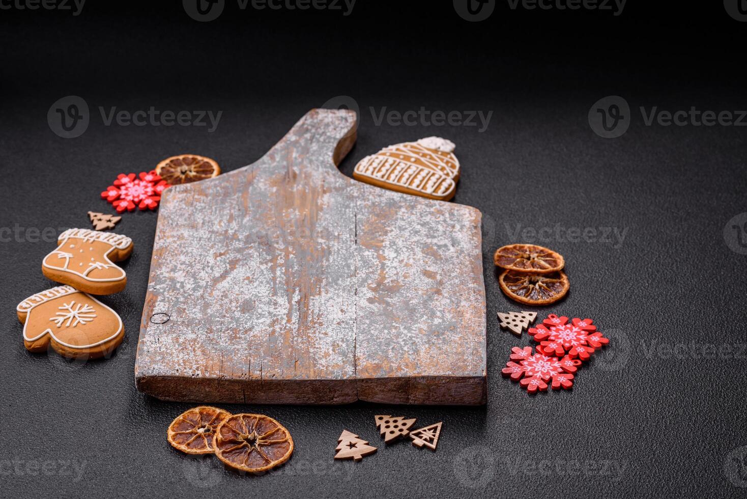 Empty wooden cutting board with copy space with gingerbread cookies and Christmas decor photo