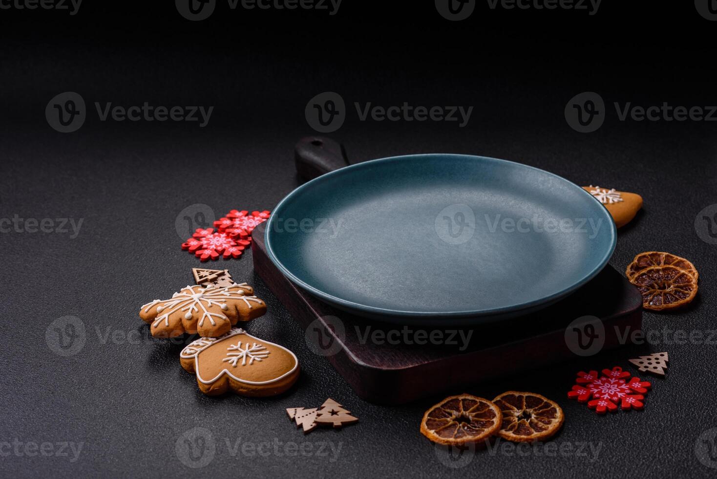 Empty round ceramic copy space plate with gingerbread cookies and Christmas elements photo