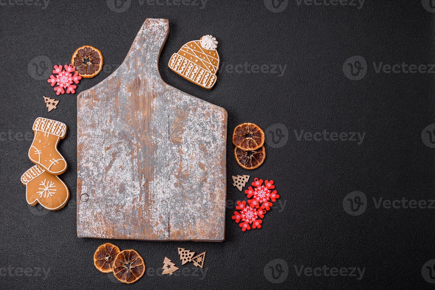 Empty wooden cutting board with copy space with gingerbread cookies and Christmas decor photo
