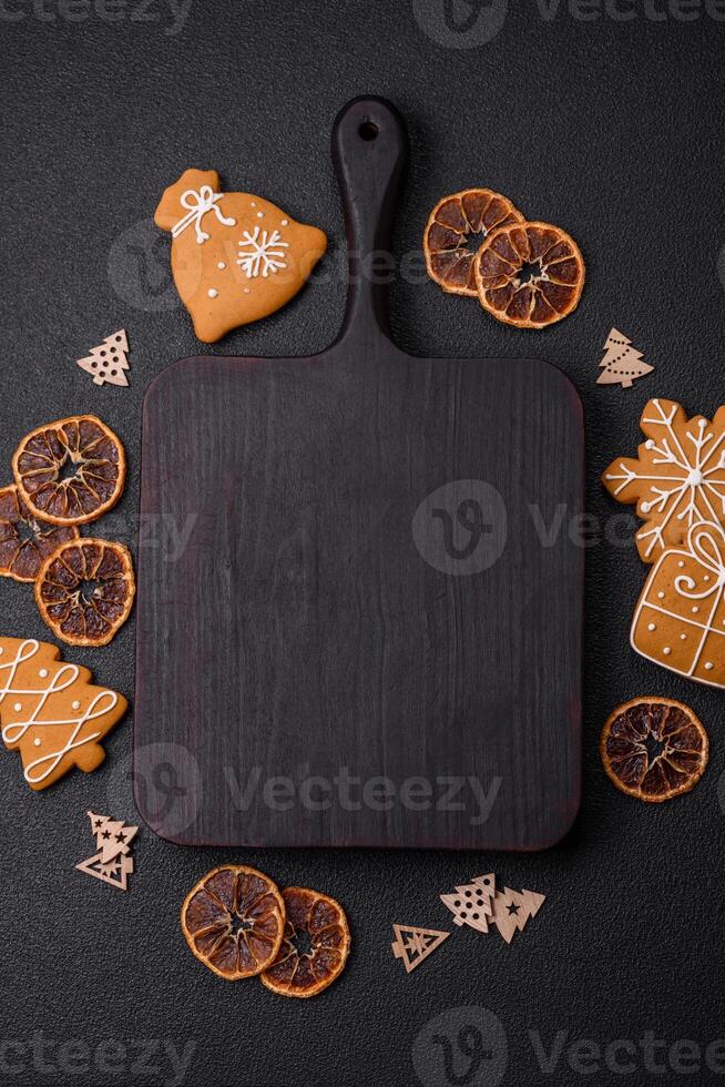 Empty wooden cutting board with copy space with gingerbread cookies and Christmas decor photo