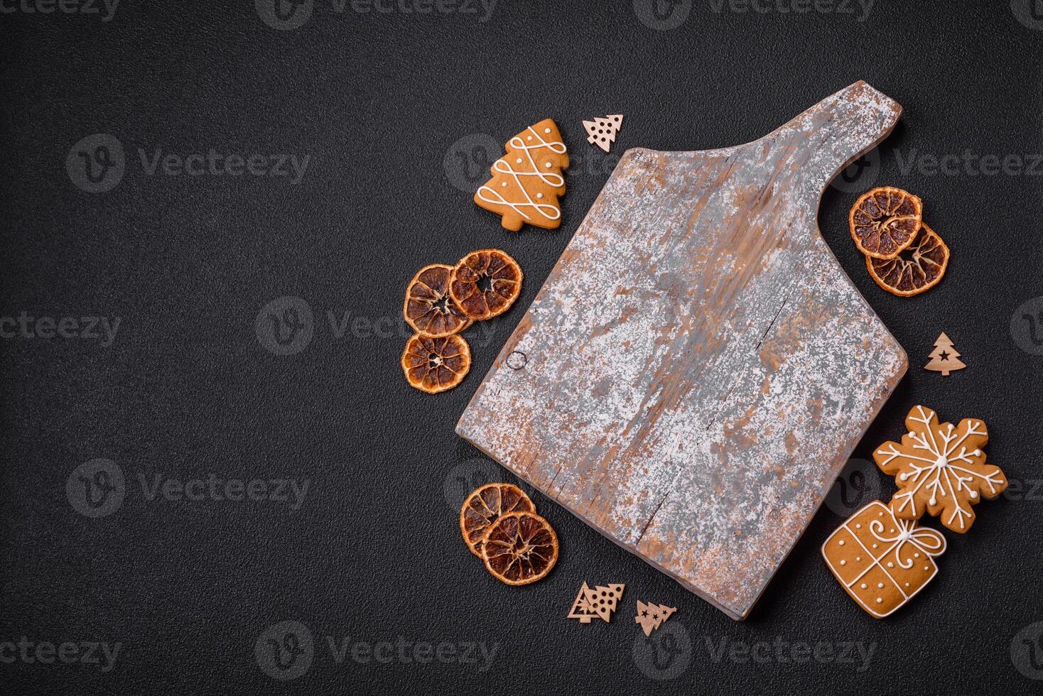 Empty wooden cutting board with copy space with gingerbread cookies and Christmas decor photo