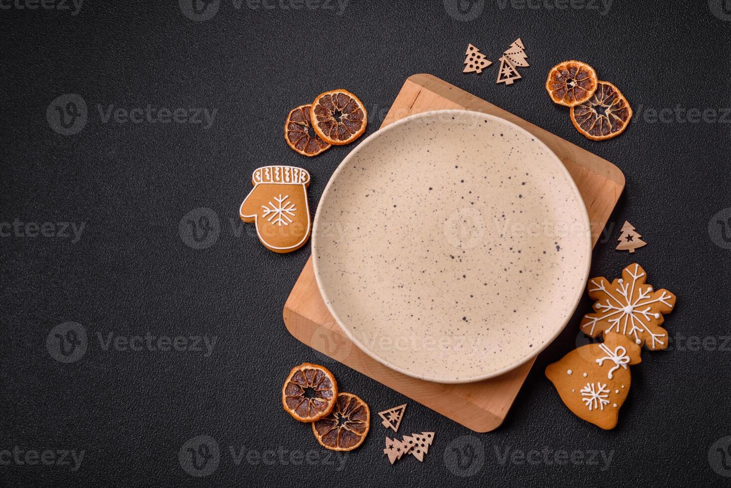Empty round ceramic copy space plate with gingerbread cookies and Christmas elements photo