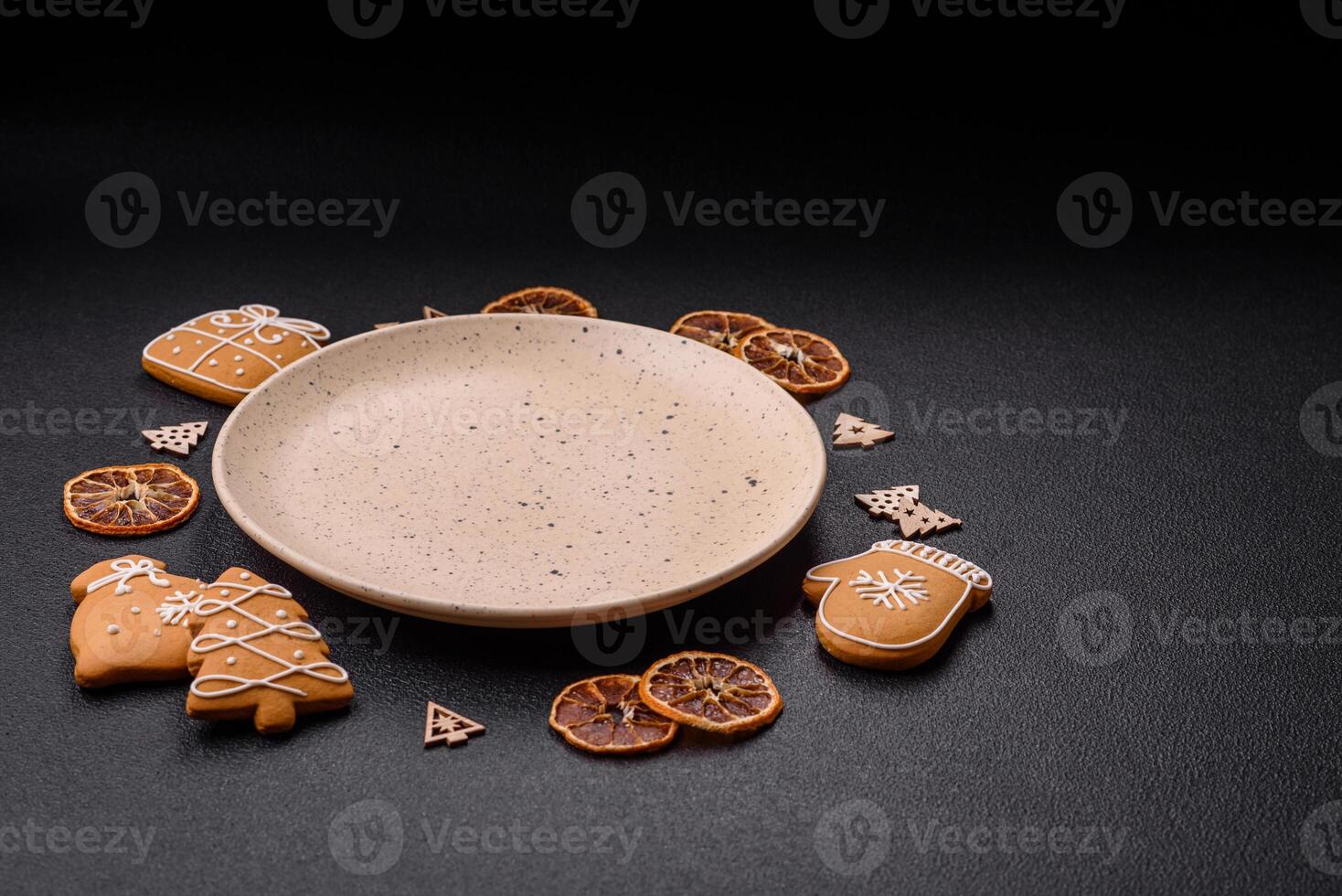 Empty round ceramic copy space plate with gingerbread cookies and Christmas elements photo
