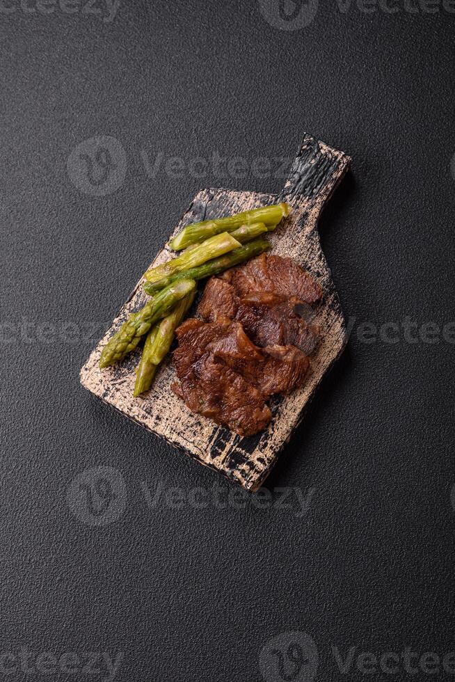 Juicy beef or pork cut into slices with boiled asparagus photo