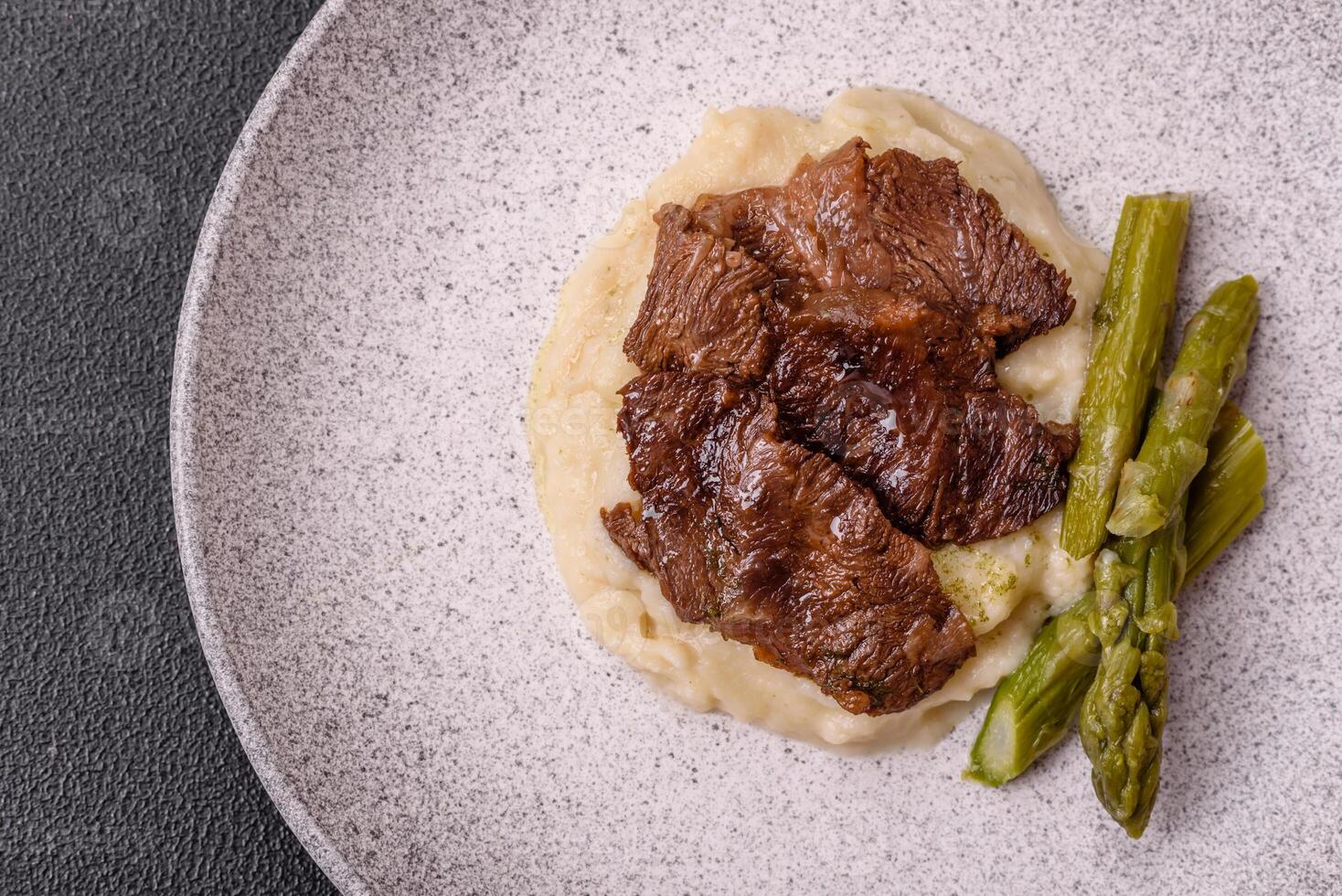 Juicy beef or pork cut into slices with boiled asparagus photo