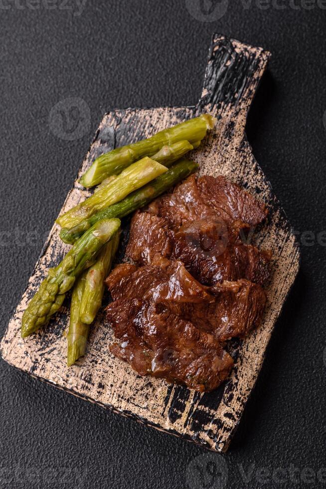 Juicy beef or pork cut into slices with boiled asparagus photo