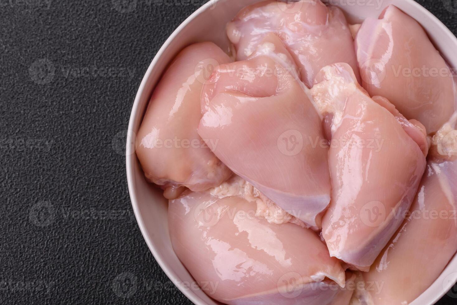 Fresh chicken fillet on a dark concrete table with spices and herbs photo