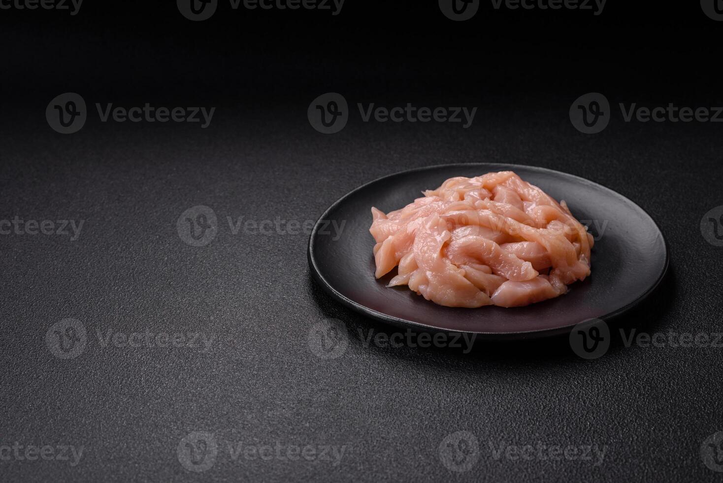 Raw chicken fillet cut into strips with spices and herbs photo