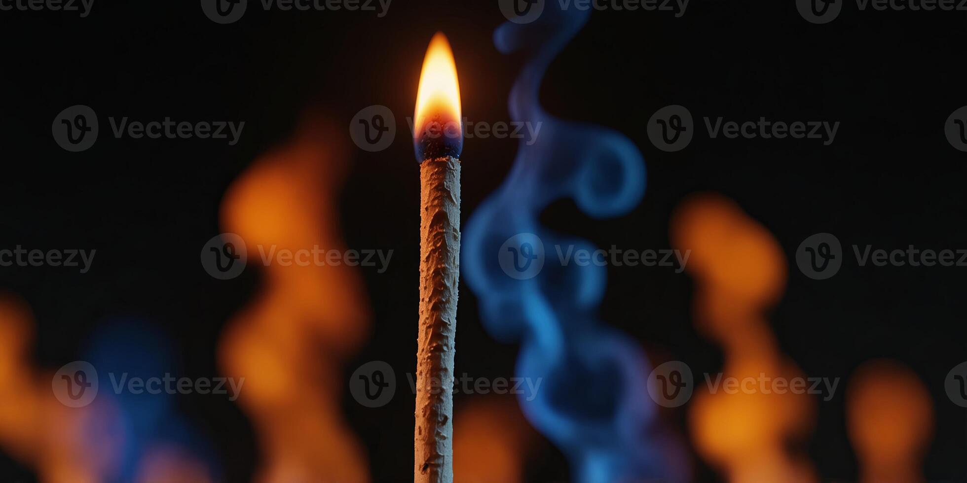 Burning matchstick with colorful abstract flames on black background. photo