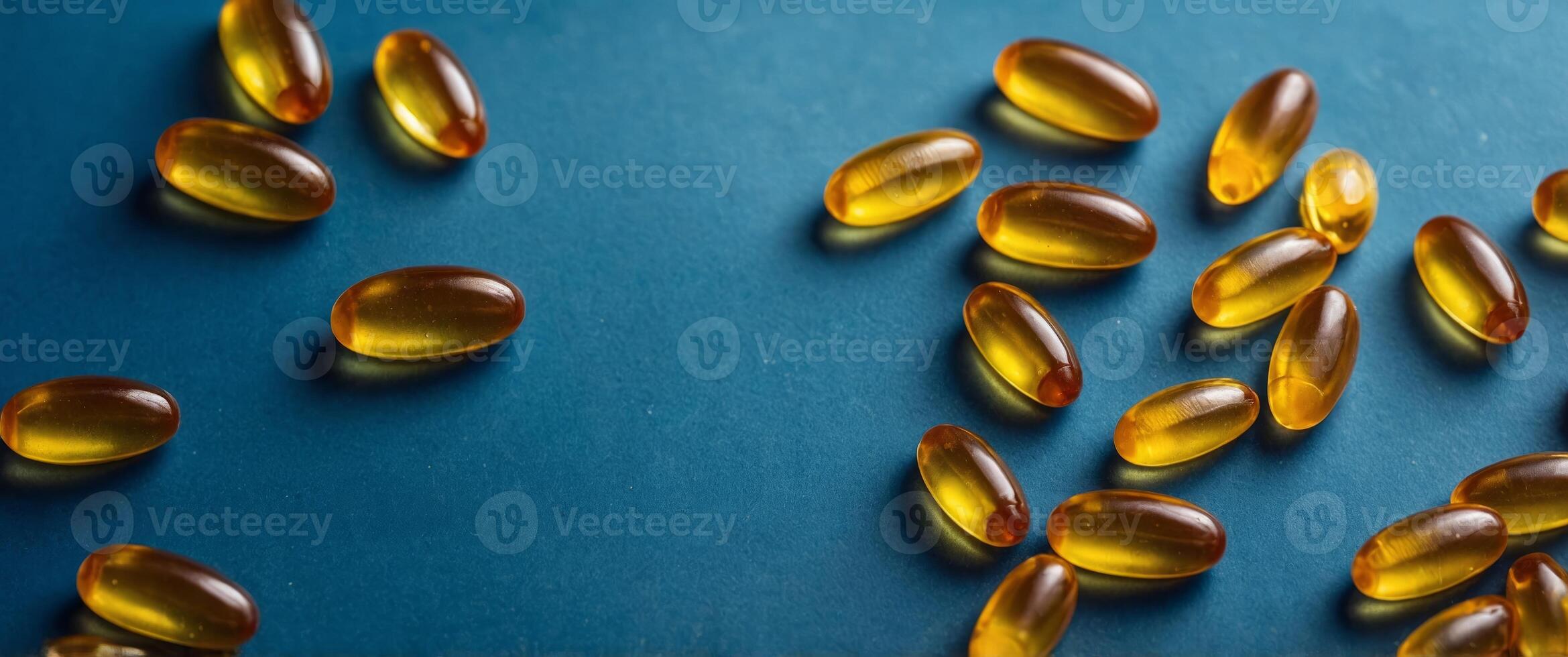 yellow fish oil omega 3 6 9 capsules soft gels on blue background top view with copy space. photo