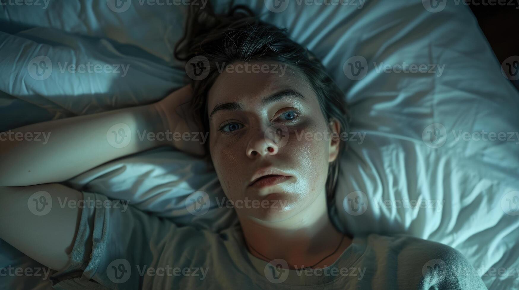 A woman lies in bed staring at the ceiling as she struggles with feelings of loneliness photo