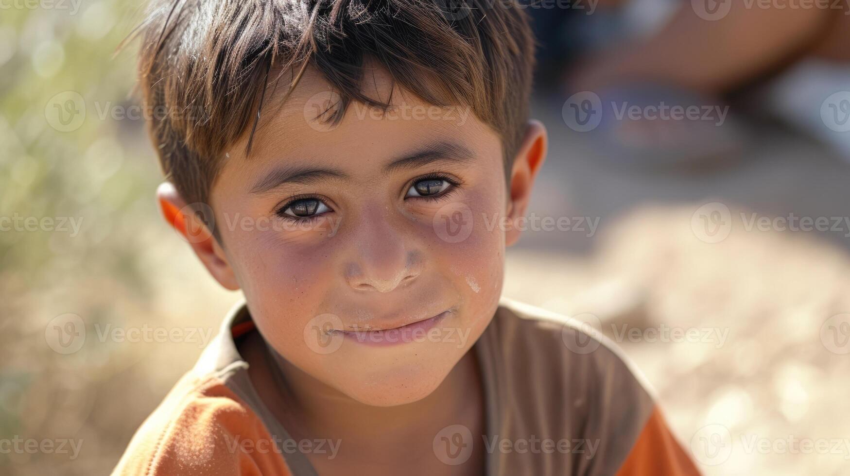 A young boy with a shy smile and bright eyes grateful for the safety and opportunities he has found after seeking asylum with his family photo