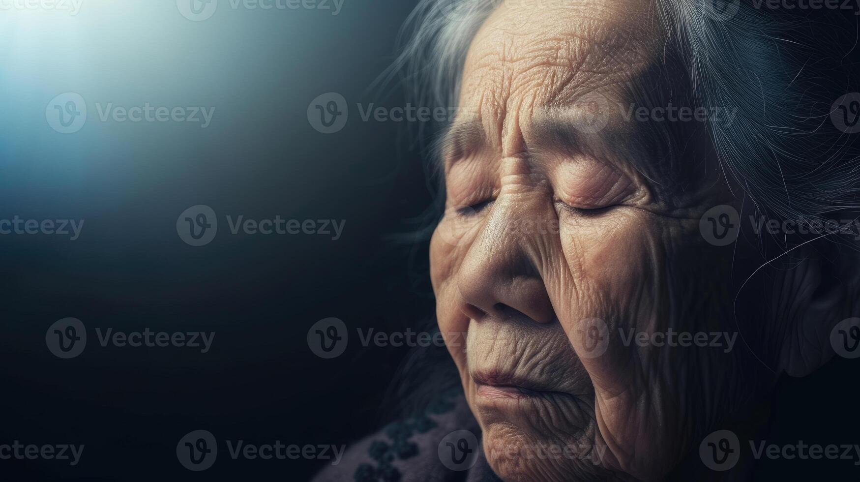 An elderly woman with her head bowed and eyes closed seeking guidance in the midst of her spiritual crisis photo
