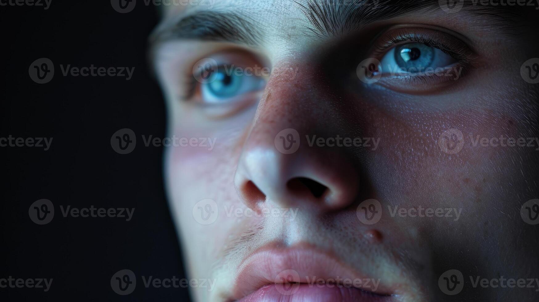 Closeup of a young mans face the faintest hint of a smile on his lips as he finally begins to feel comfortable in his own skin photo