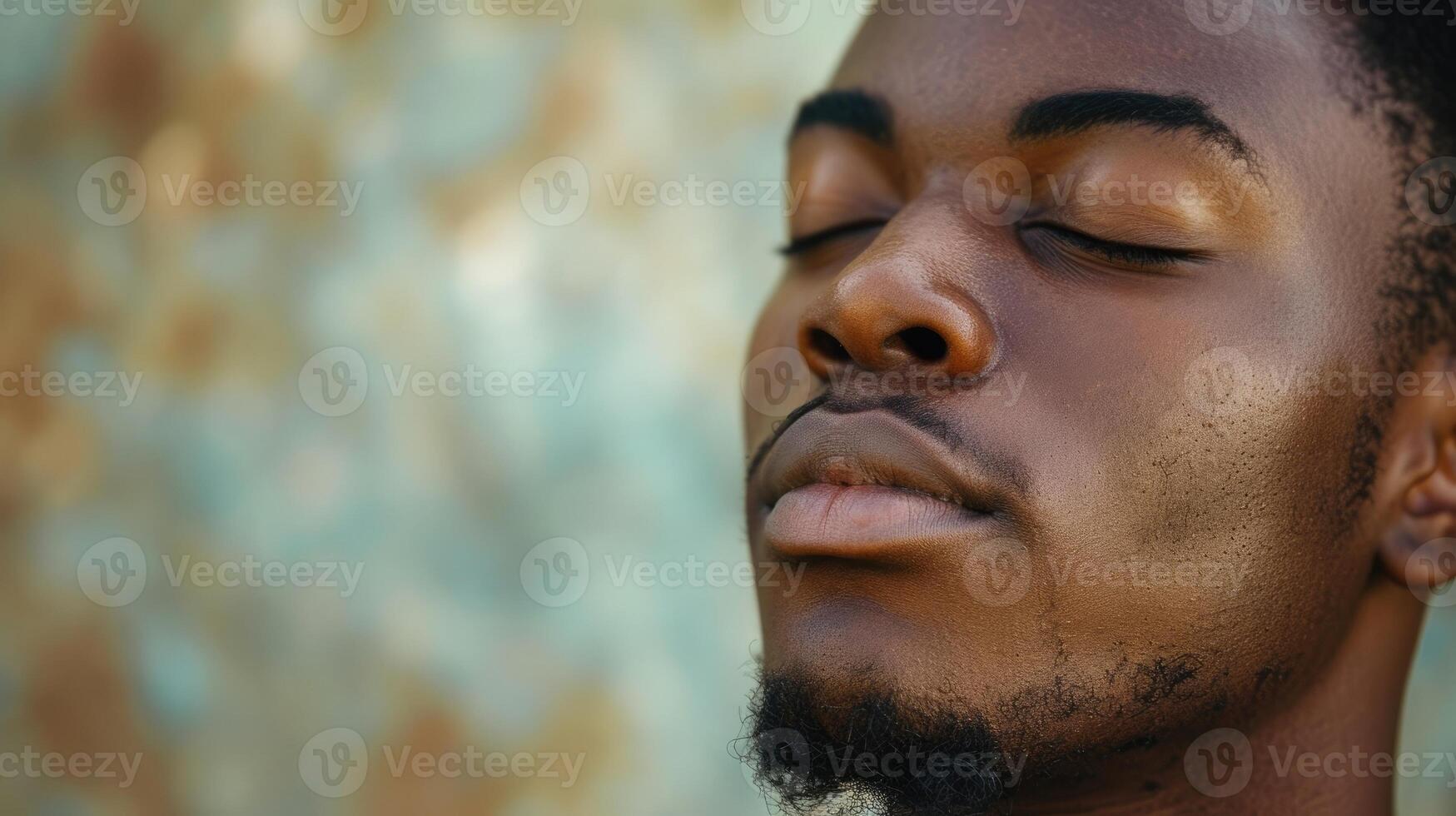 A young black man with closed eyes and a solemn expression deep in thought about his faith photo