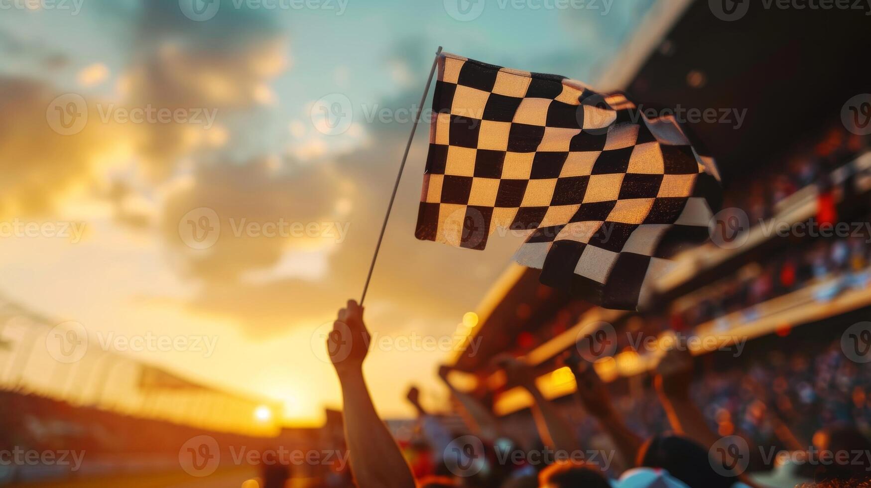 The camera zooms in on the checkered flag as it is being waved in front of a cheering crowd capturing the moment of triumph photo