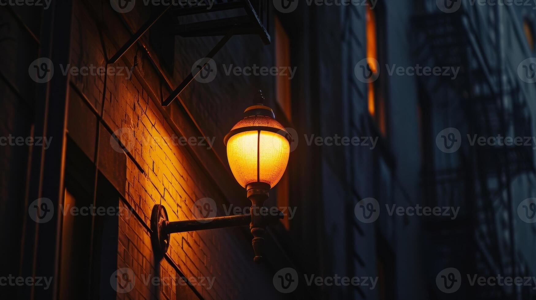 A dramatic closeup of a solitary street lamp its warm glow contrasting with the deep shadows of the surrounding buildings photo