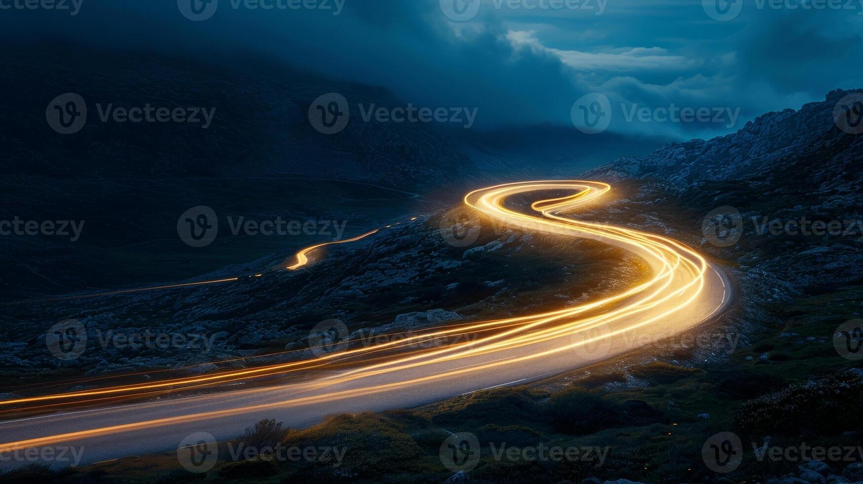 A tight turn on the mountain road with the headlights of a single car illuminating the way photo